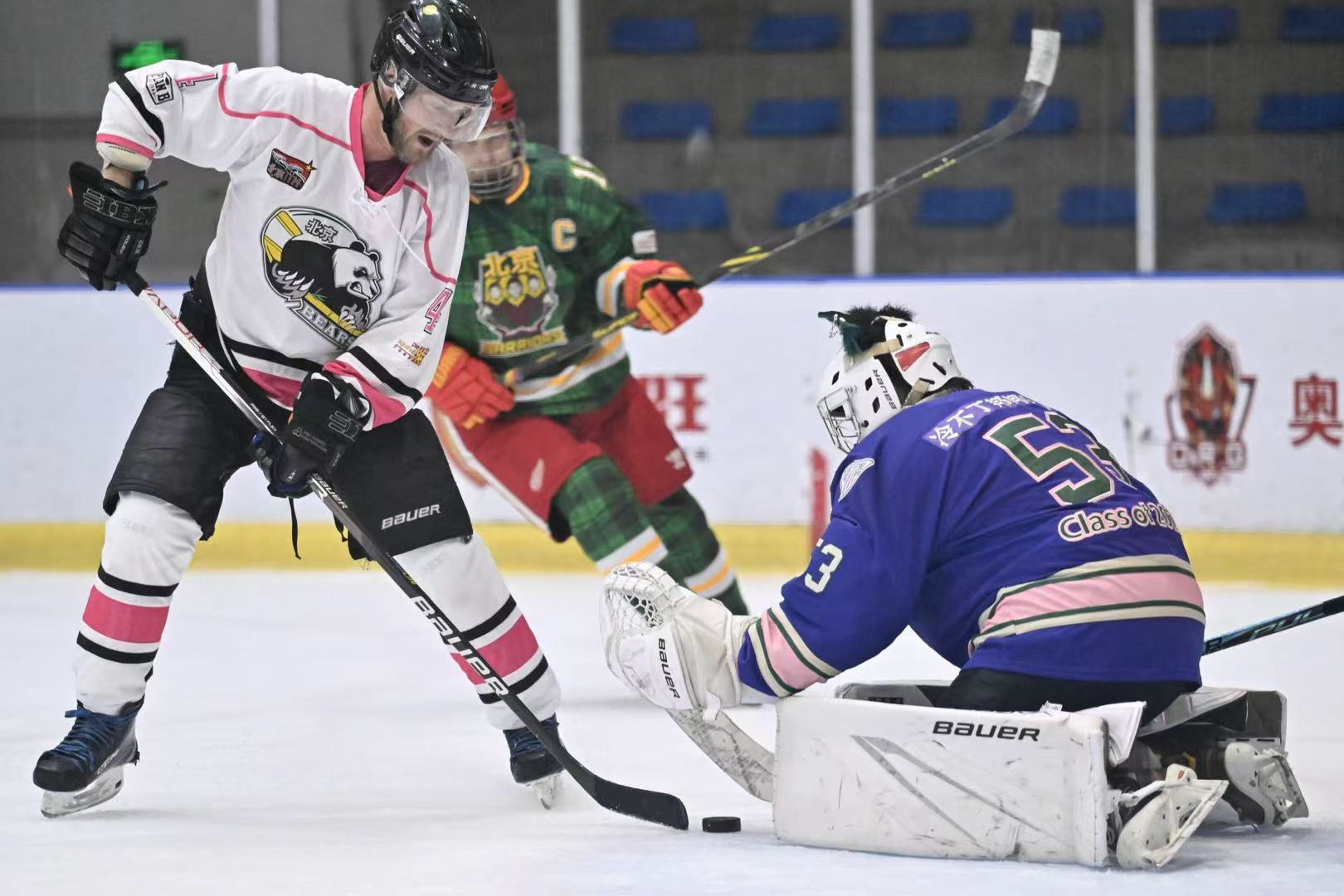 Aken set low in the crease as a Bears player approaches the puck