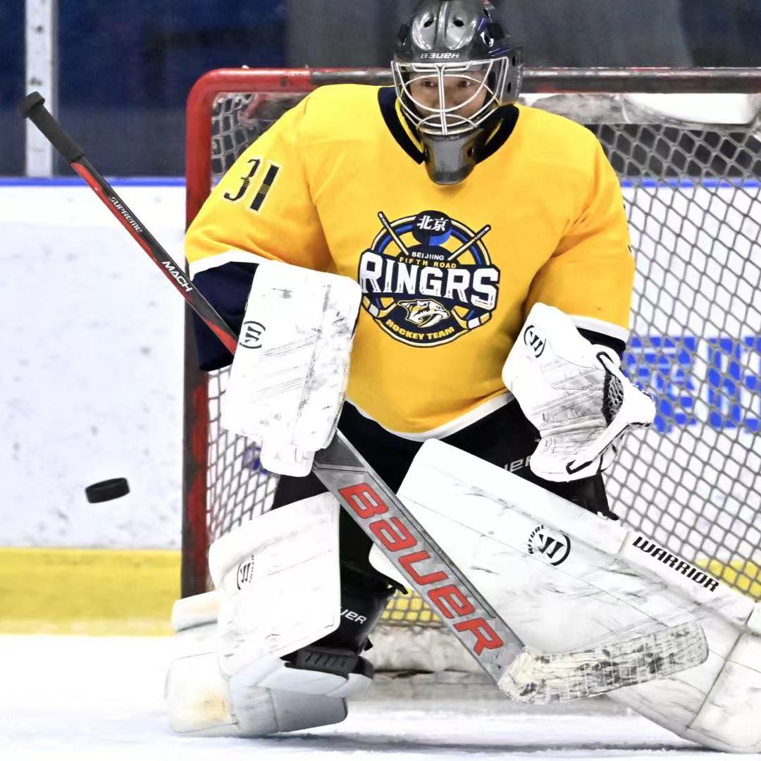 Goalie in a yellow Ringers jersey set in the crease