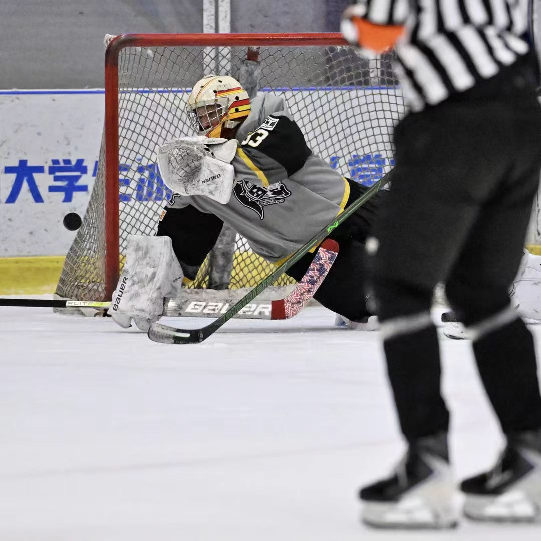Goalie making a glove save through traffic in front of the net