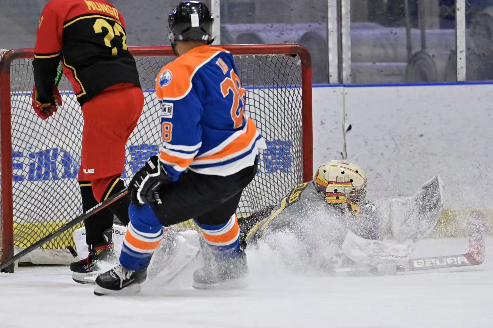 Goalie sliding across the crease as players screen the net