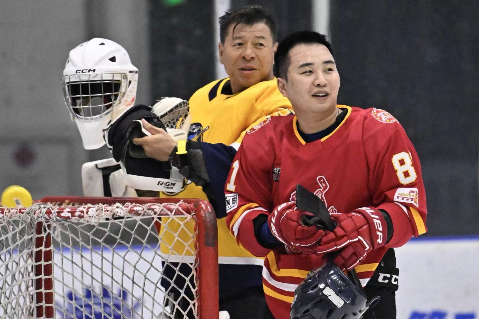 Ray beside the net with a Hot Wings player during a break in play