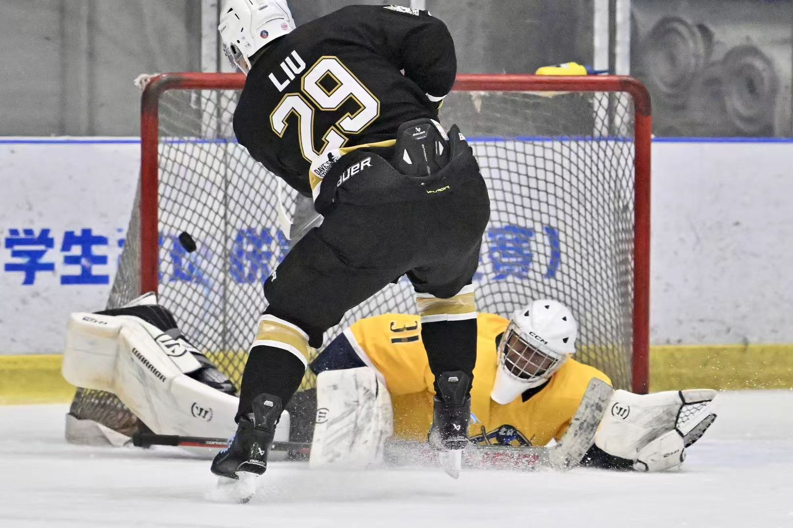 Ray stretched across the crease as a Revs player attacks the net